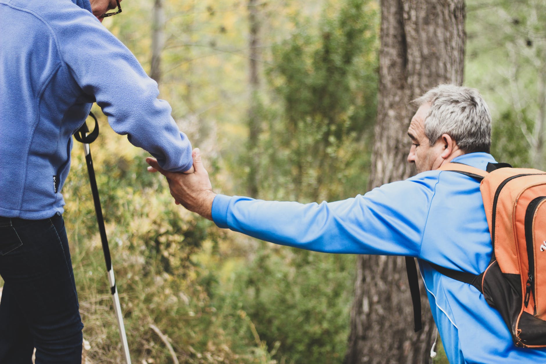 photo of two old man helping each other